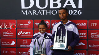 الإثيوبيبان نيبرت ميلاك وأنشينالو ديسي يحتفلان بالكأسين بعد فوزهما بسباق النخبة للرجال وسباق النخبة للسيدات في ماراثون دبي